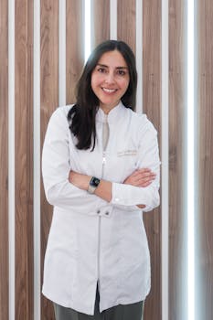 Female doctor standing confidently in modern clinic with wood panel wall.