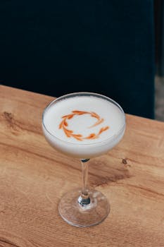 A beautifully crafted cocktail with an artistic foam garnish, served in a classic glass.
