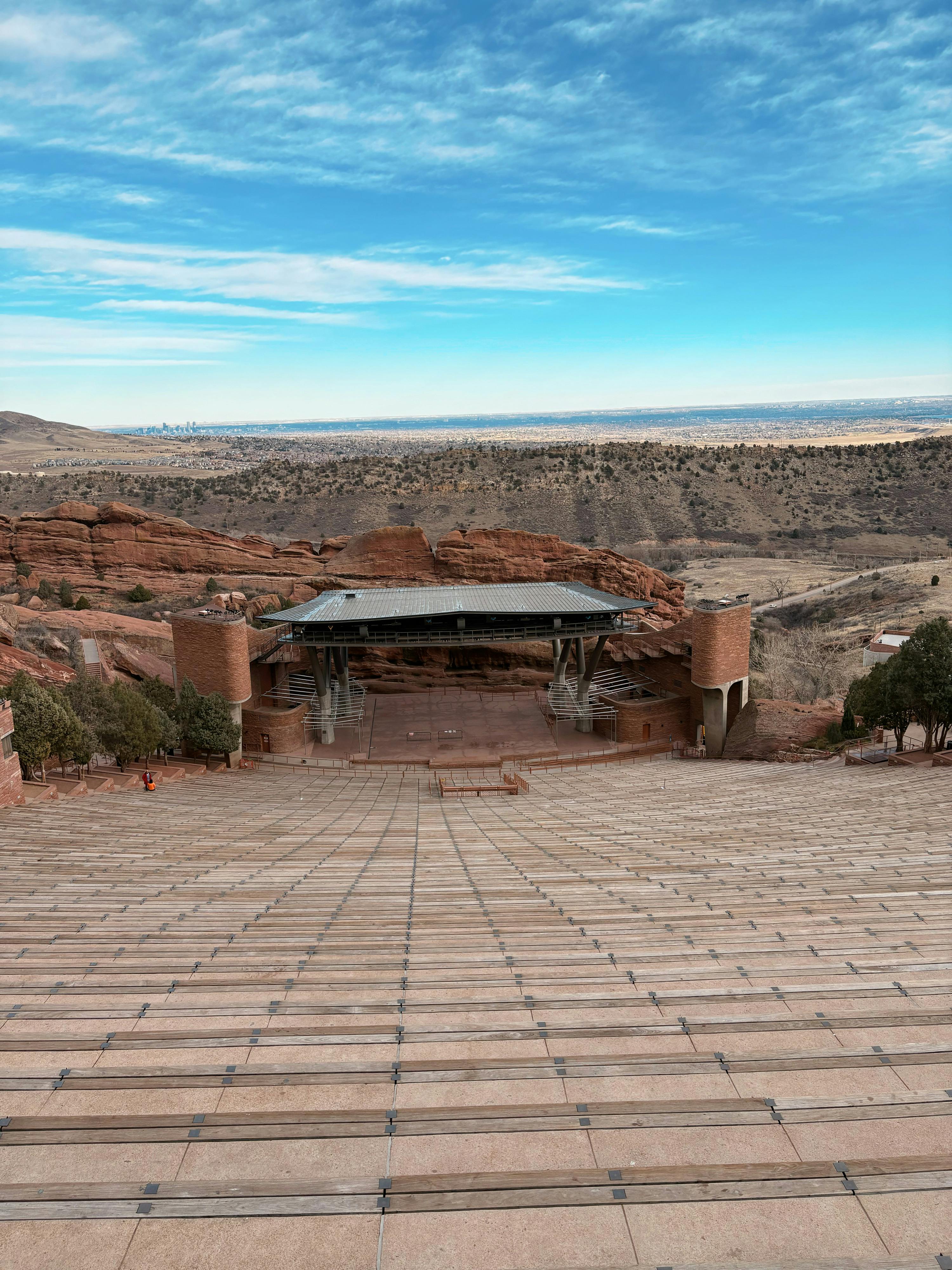 Free Scenic view of empty Red Rocks Amphitheater in Colorado with rocky backdrop and blue sky. Stock Photo