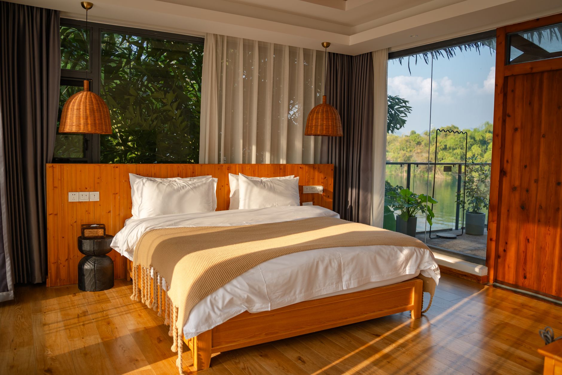 A sunlit bedroom with wood accents and a serene view, ideal for relaxation.