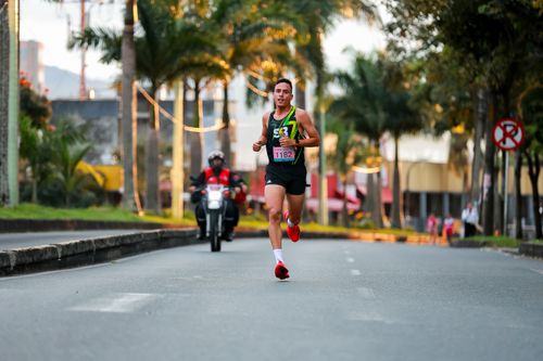Free Athlete running in a city marathon during daytime with vibrant surroundings. Stock Photo