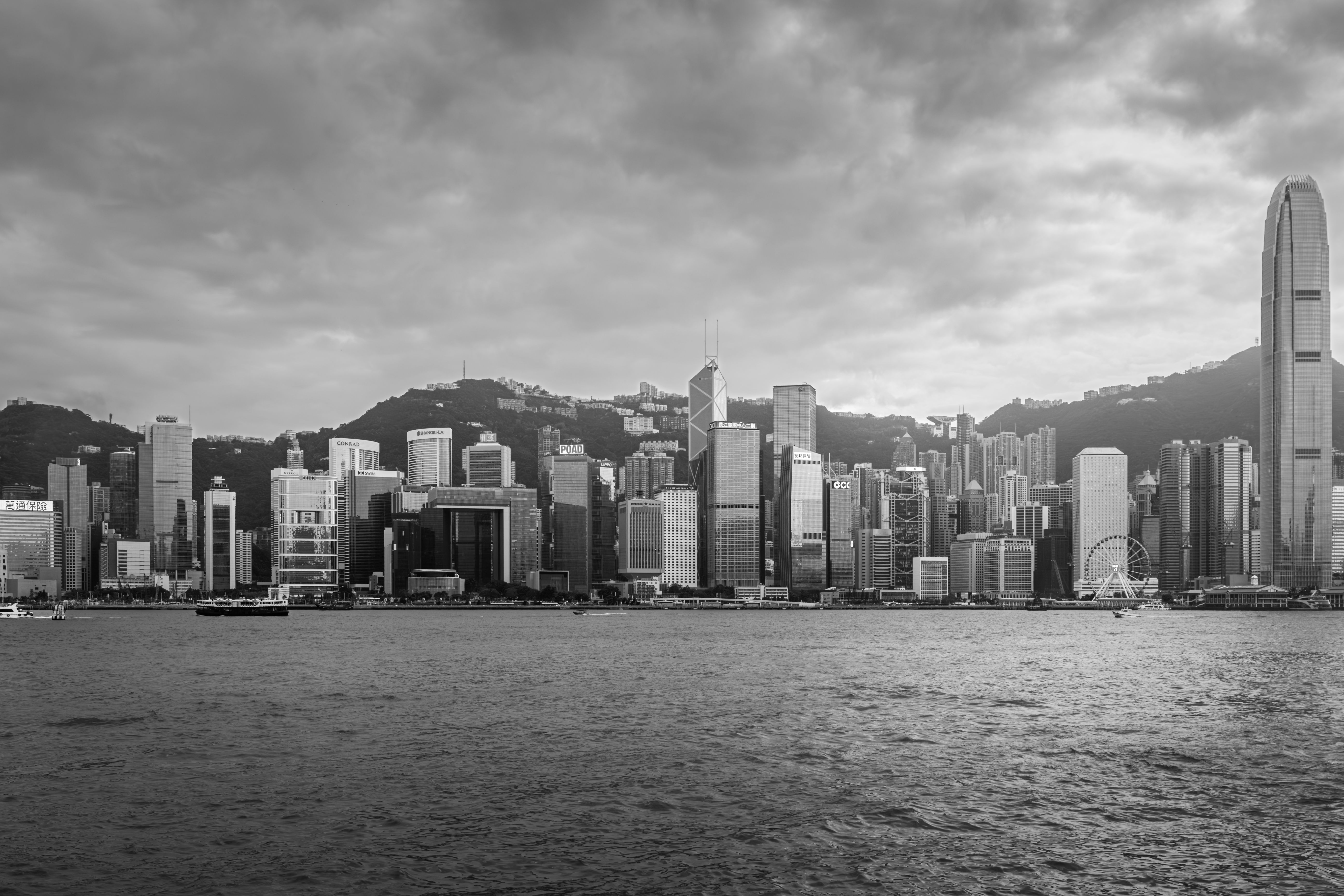 Dramatic black and white image of Hong Kong's skyline viewed from the harbor.