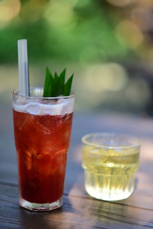 Free Two refreshing ice-cold drinks on an outdoor table with a vibrant summer background. Stock Photo