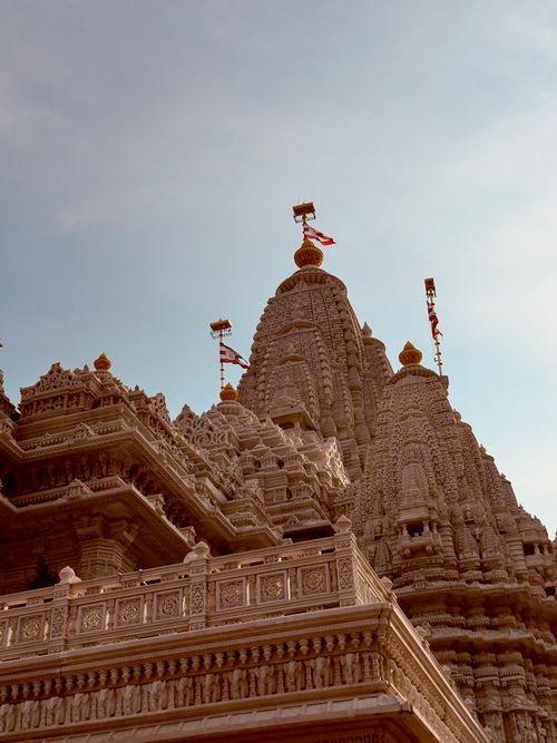 Free Detailed view of a Hindu temple's intricate exterior architecture under a clear sky. Stock Photo