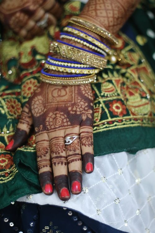 Free Close-up of a bride's hand with mehendi and jewelry, showcasing cultural elegance. Stock Photo