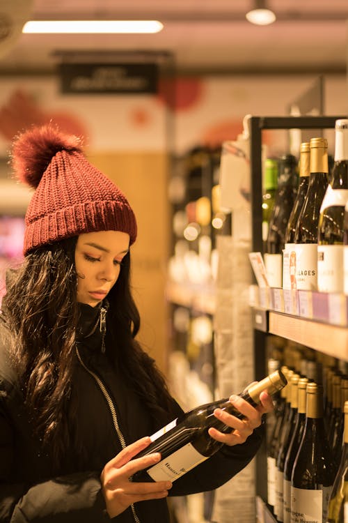 Woman picking wine in store
