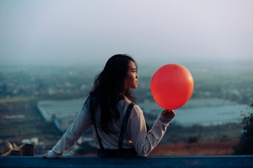 Woman Wearing White Dress Shirt While Holding Red Balloon