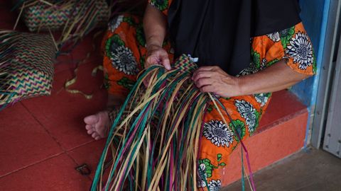 Traditional Indonesian basket weaving by a woman in South Kalimantan, highlighting vibrant cultural heritage.