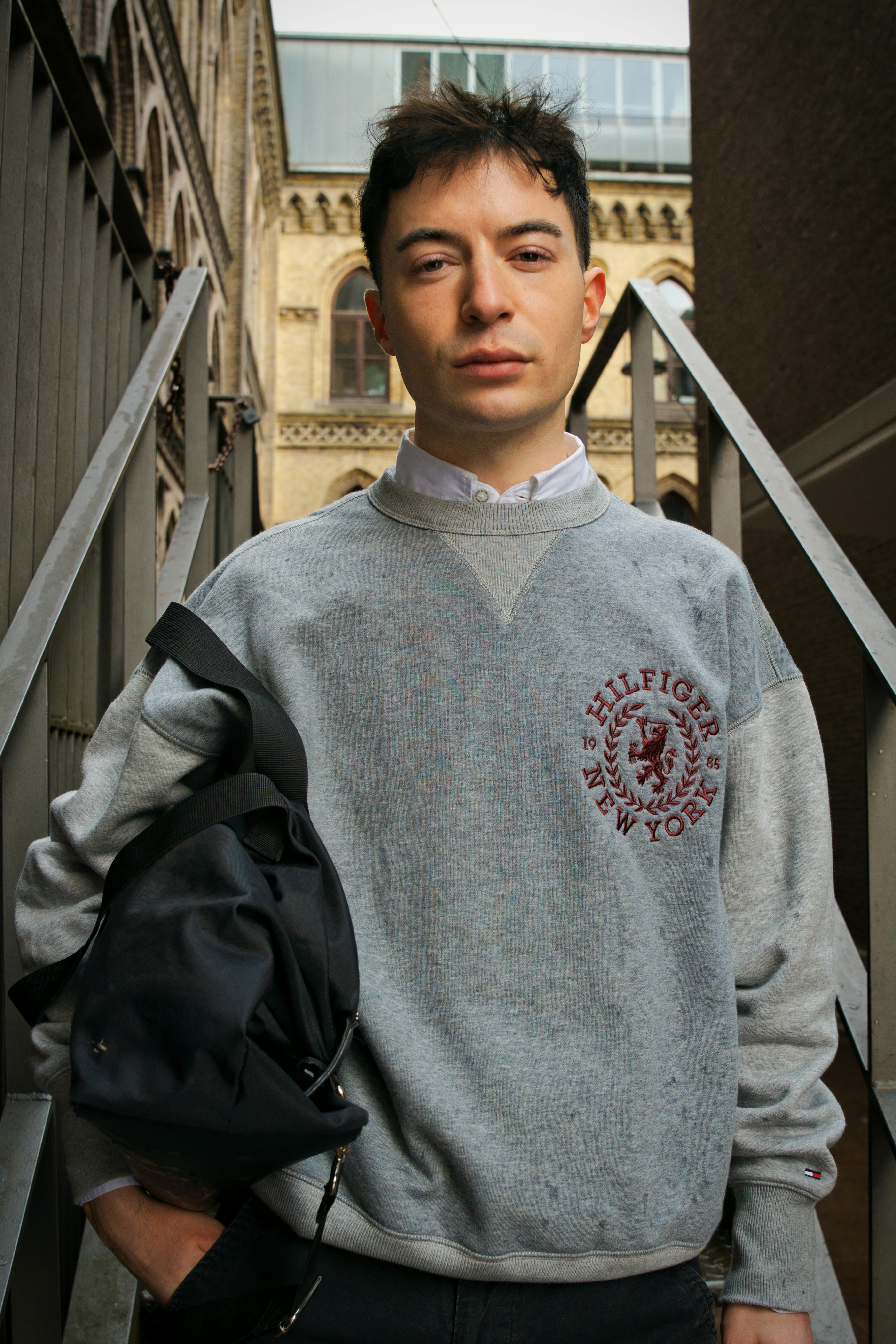 A young man in casual attire poses outdoors in Bremen, Germany.