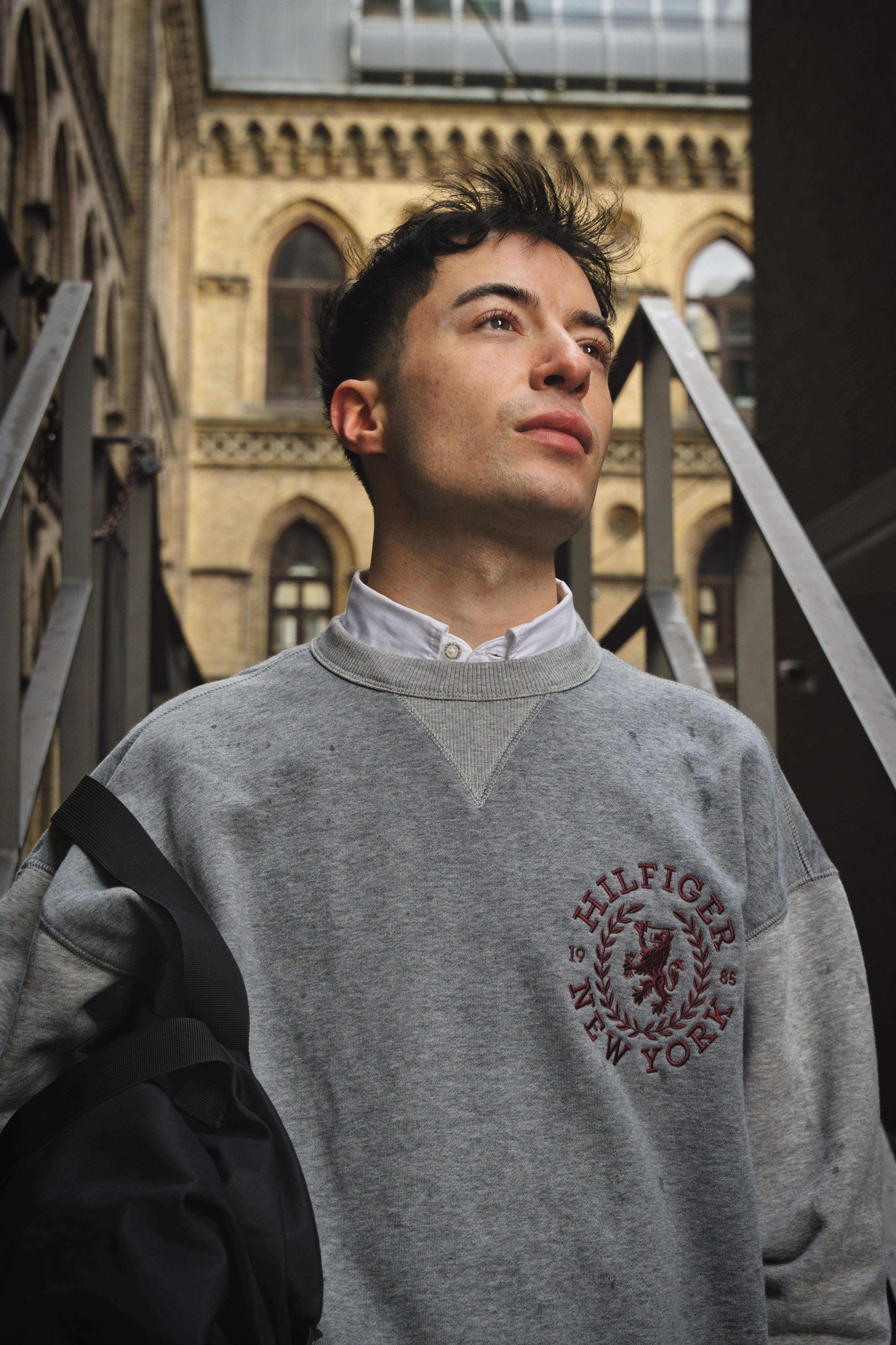 Portrait of a young man in a casual sweatshirt in Bremen, Germany's urban architecture.