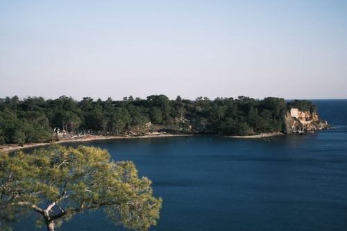 Free Beautiful coastal view of a forested peninsula surrounded by blue sea under a clear sky. Stock Photo