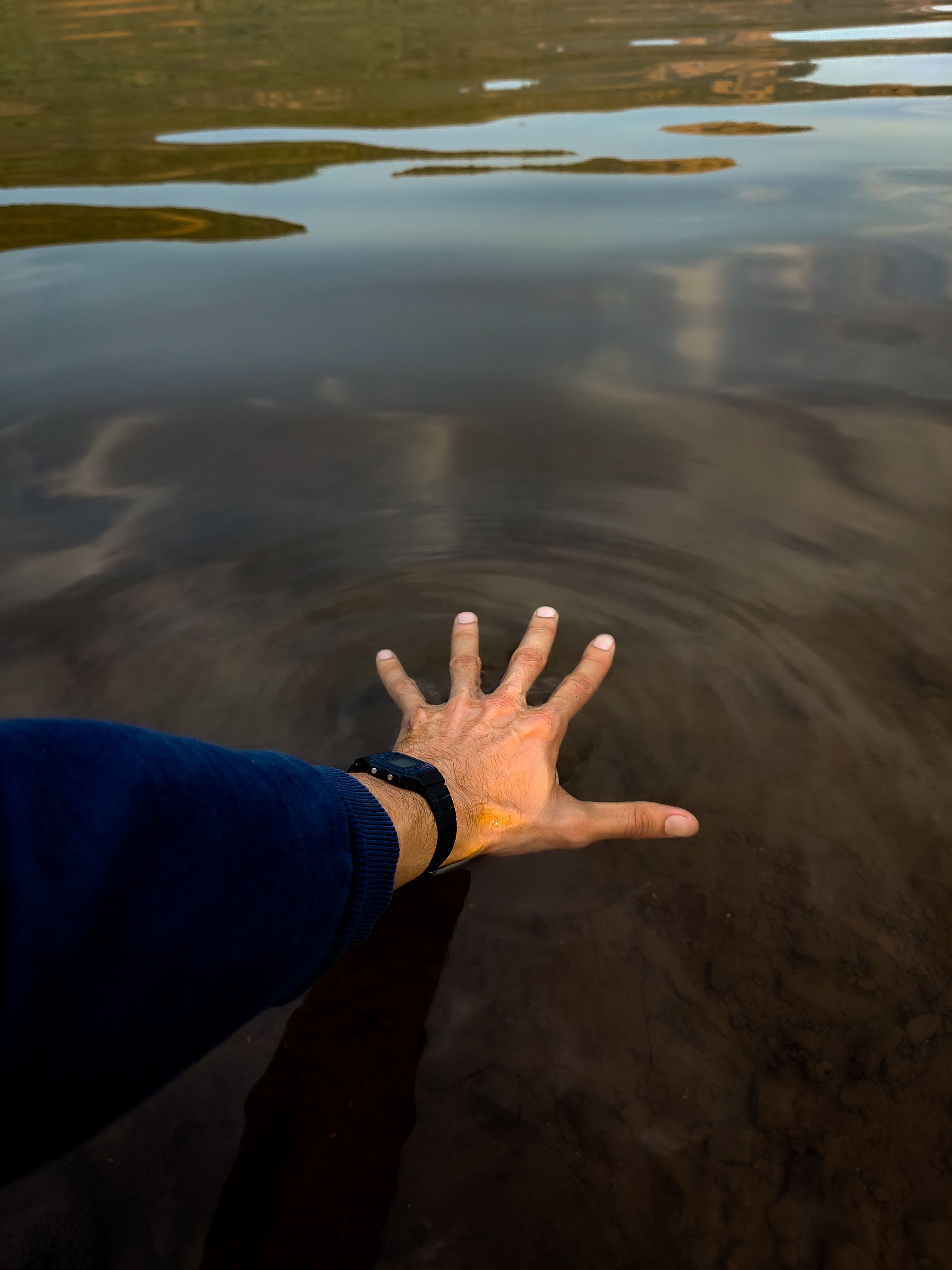 Hand Touching Calm Water Surface Outdoors · Free Stock Photo