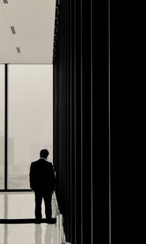 Silhouette of a businessman in a modern office with cityscape view in Shibuya, Tokyo.