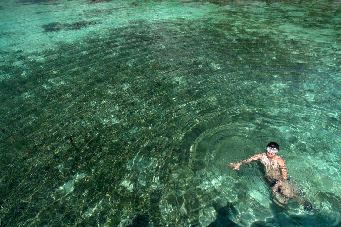 Anfänger lernt Schnorcheln im flachen klaren Wasser