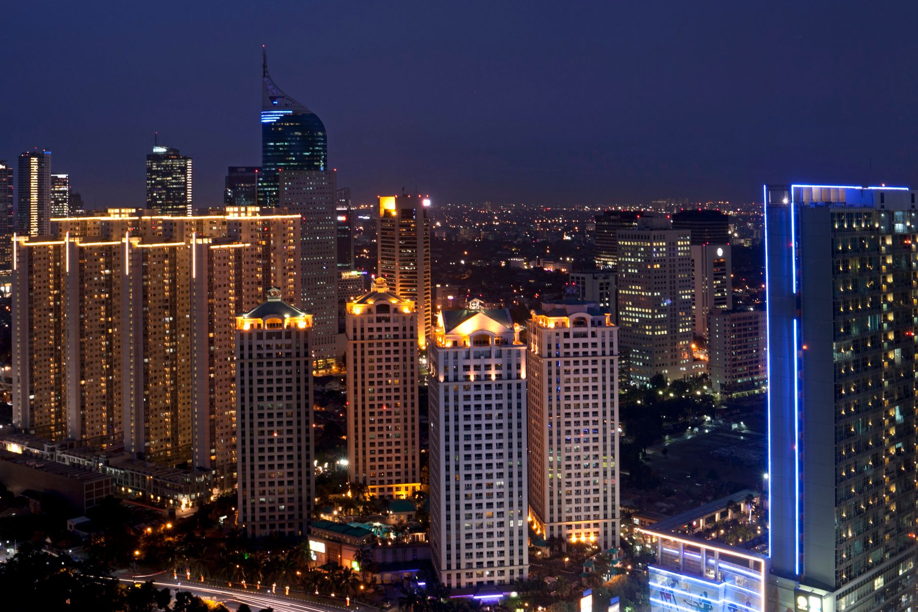 A sophisticated high-rise legal office at night overlooking a glowing global metropolis, representing 24-hour legal vigilance.