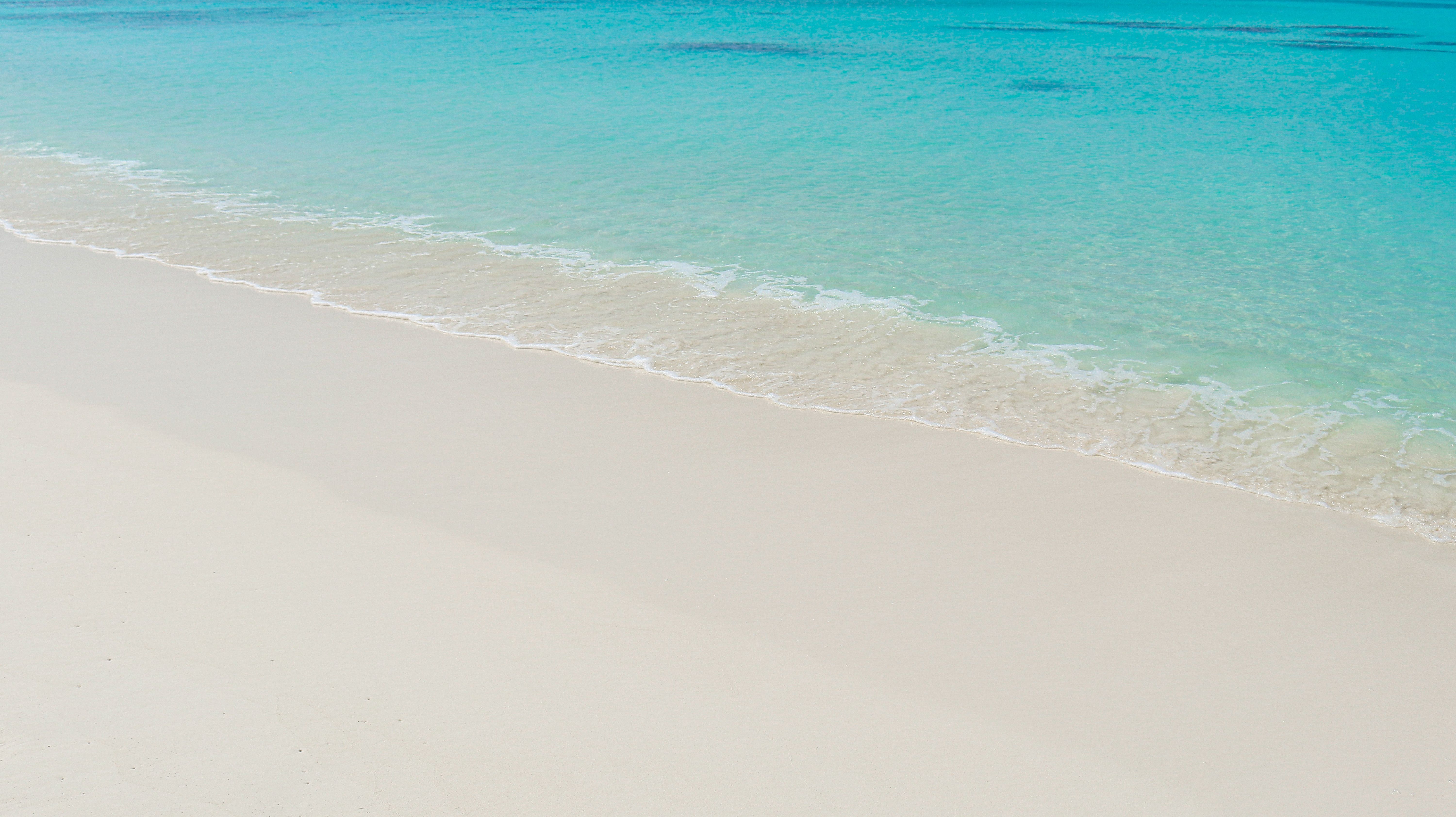 question mark drawn in the sand on a tropical beach