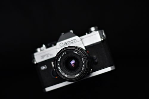 Free A detailed close-up of a vintage Canon camera lens on a black background, showcasing modern technology. Stock Photo