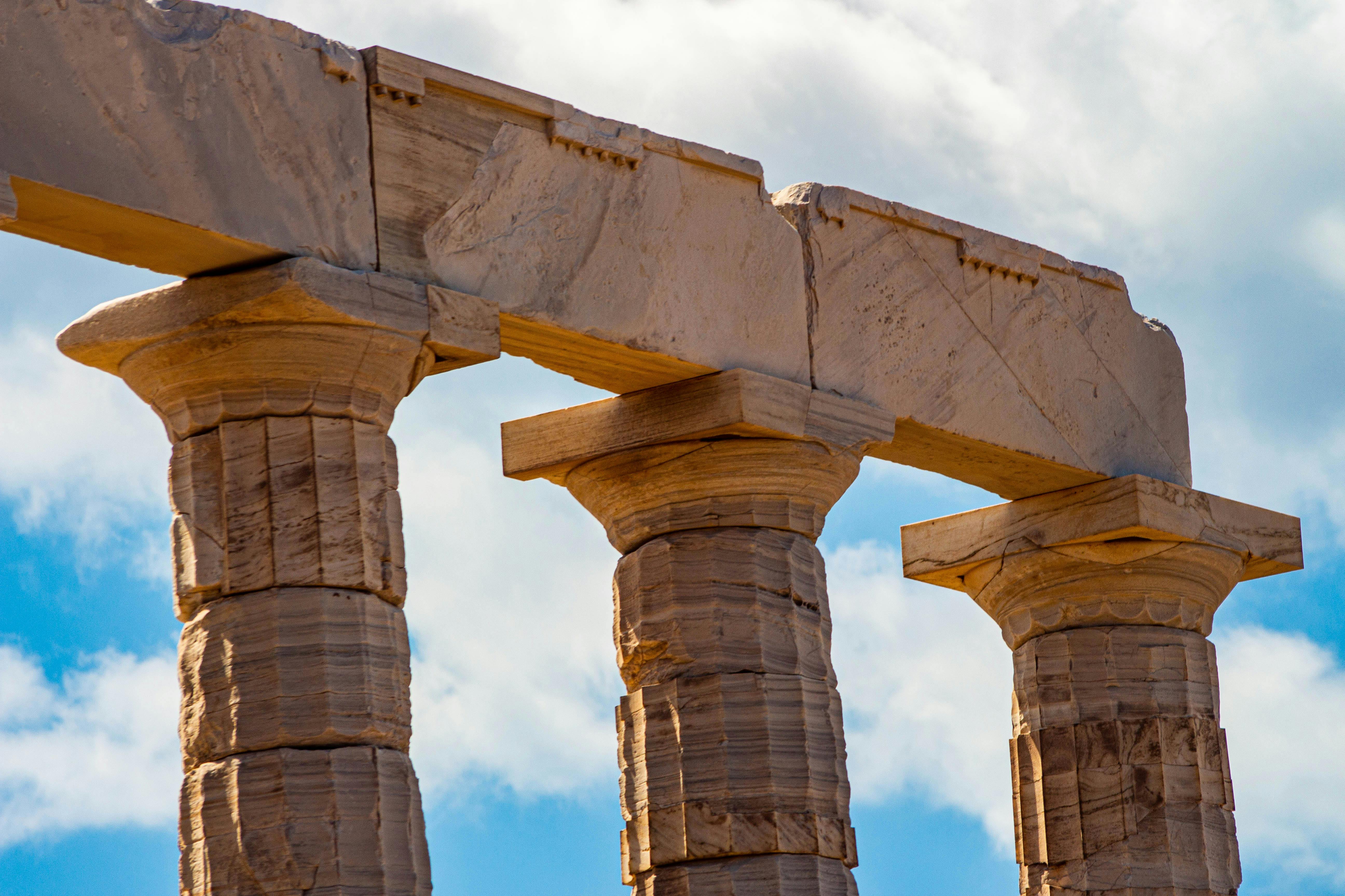 Close-up view of ancient Greek stone columns against a vivid blue sky, highlighting historical architecture. - Photo by Nikolaos D. Nomikos on Pexels