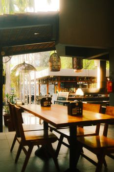 Warmly lit modern restaurant interior featuring wooden furniture and hanging lamps, perfect for dining ambiance.