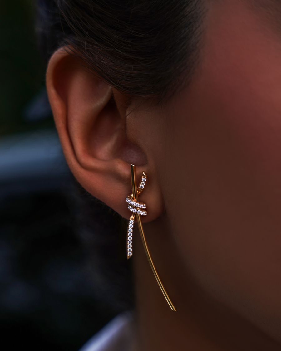 Gold earring with diamonds on a woman’s ear