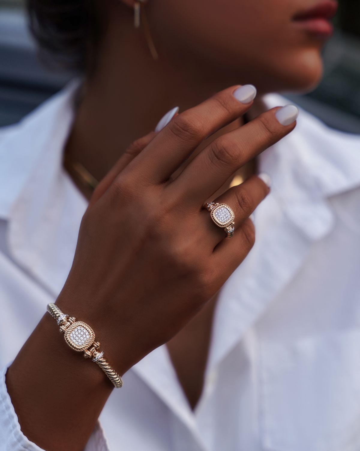 Close-up of a woman's hand wearing gold and diamond jewelry for an everyday luxury look