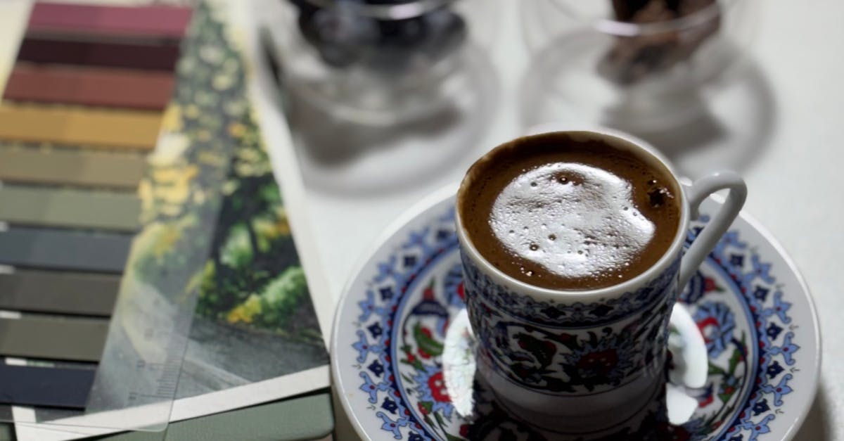 Photo by Tuğba Dönmez Stylish coffee moment with cup, candle, chocolates, and color swatches.