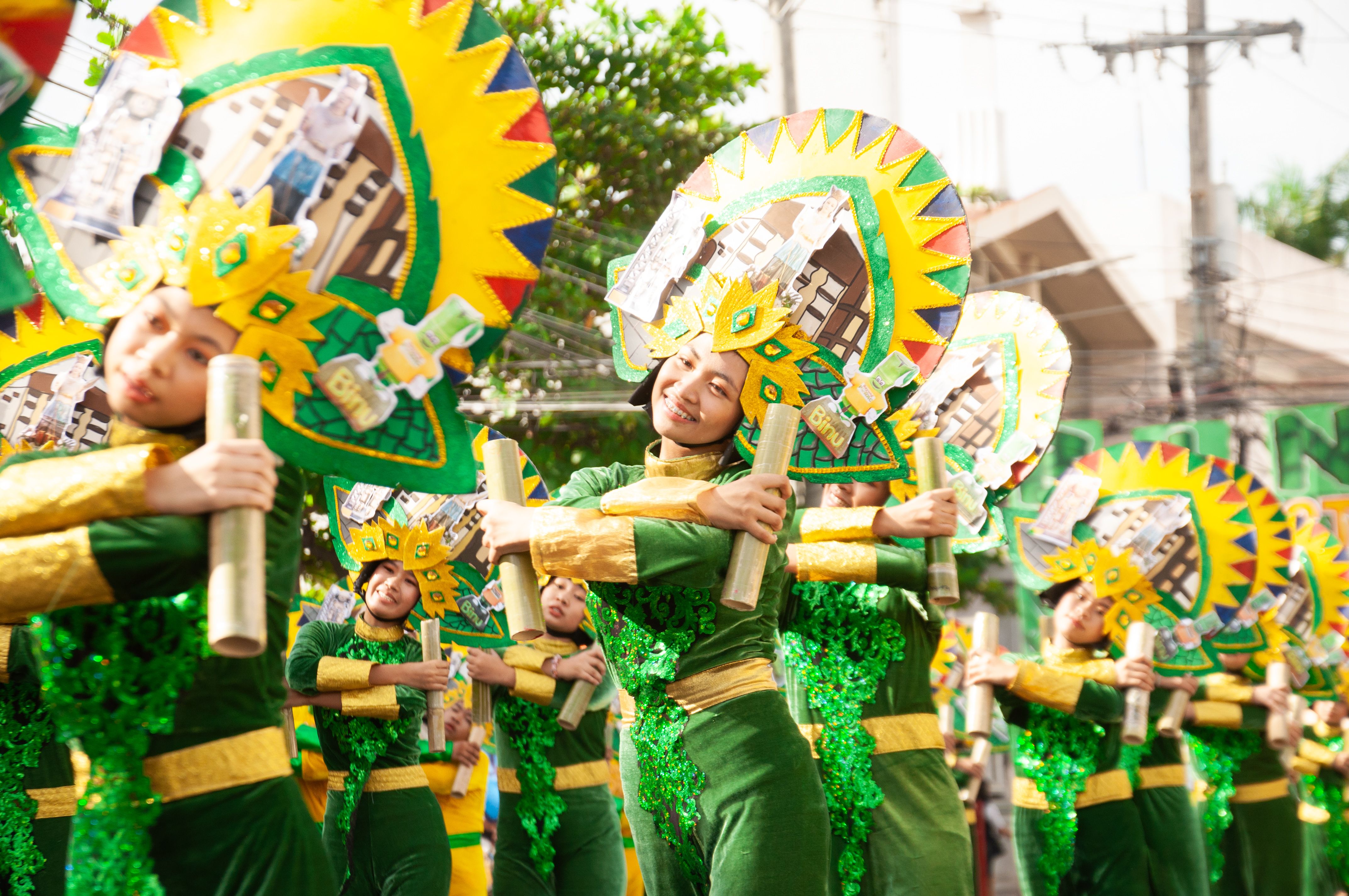 Colorful dancers in traditional attire perform at a vibrant street parade.