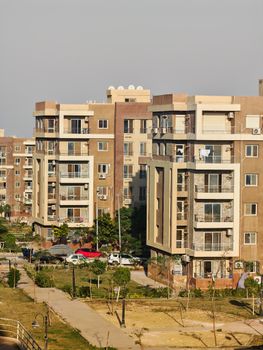 Outdoor view of a modern residential apartment complex with multiple buildings under clear sky.