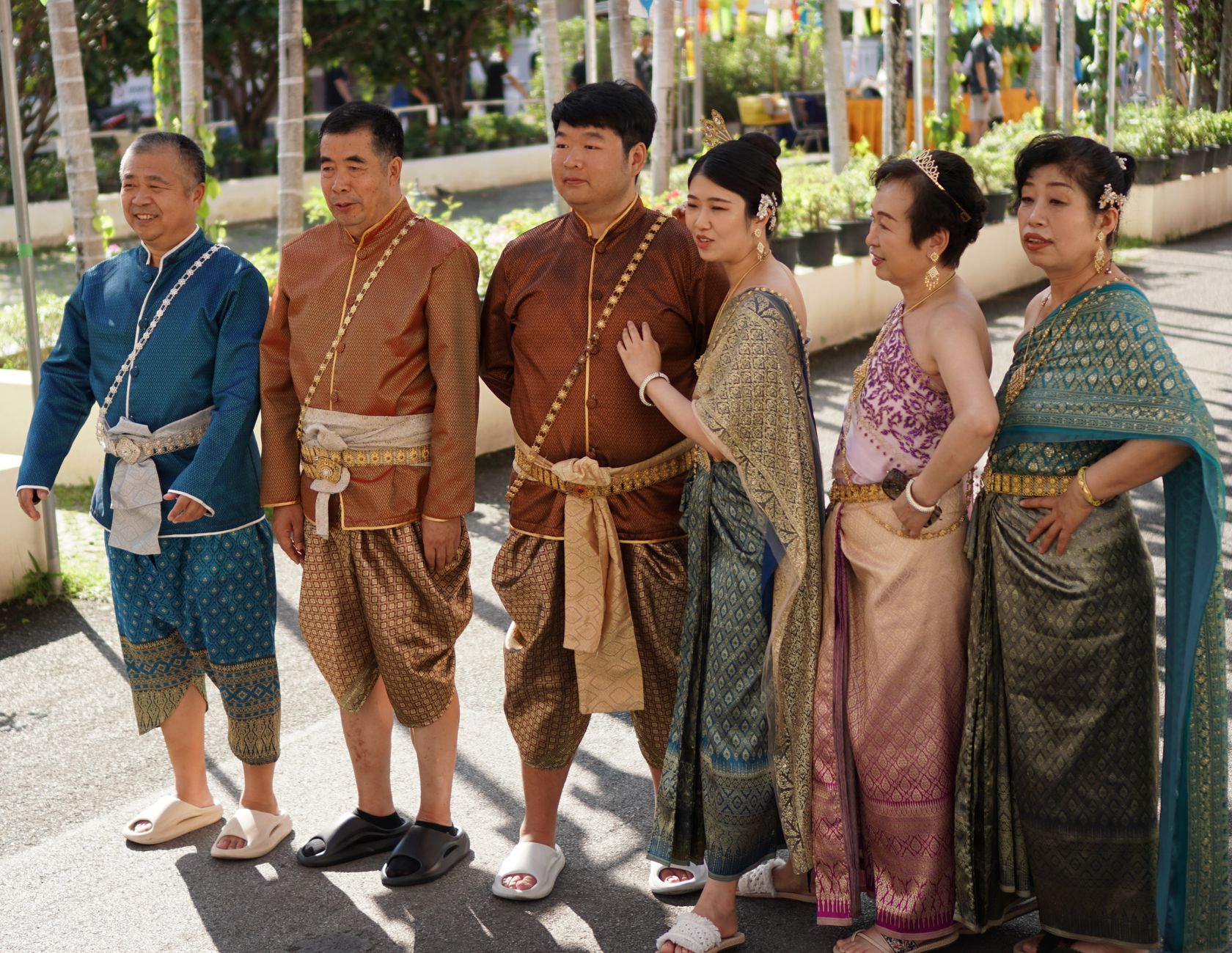A family dressed in traditional Thai attire posing outdoors at a cultural event in Chiang Mai, Thailand.