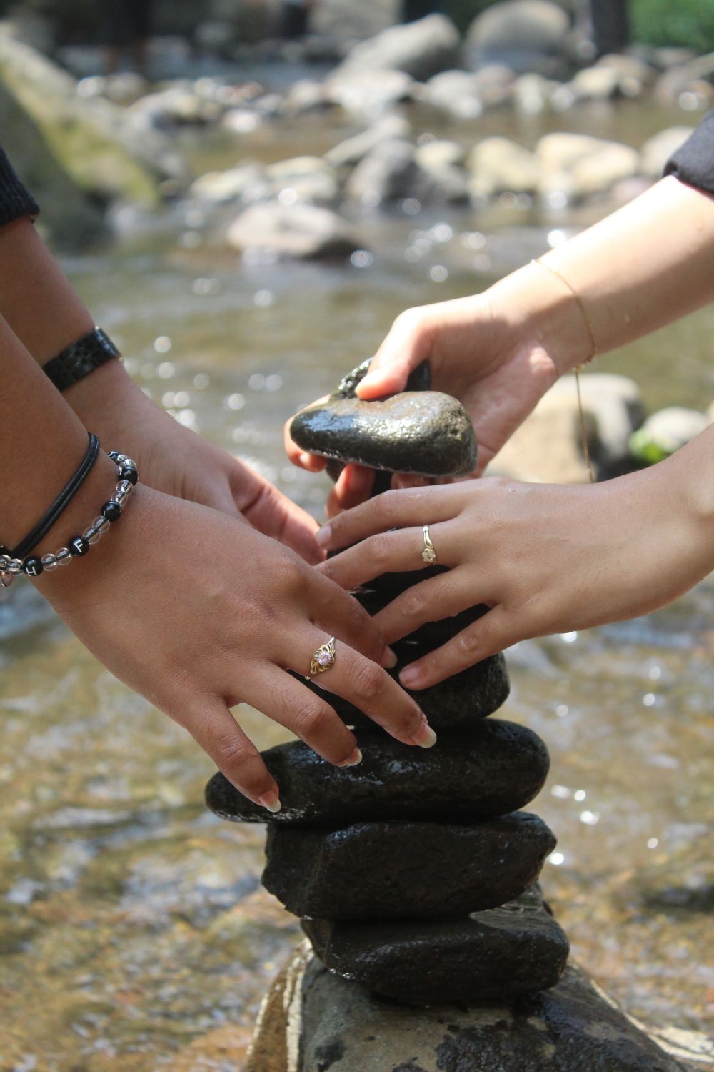 People Stacking Rocks People Stacking Stones by a Stream Outdoors · Free Stock Photo