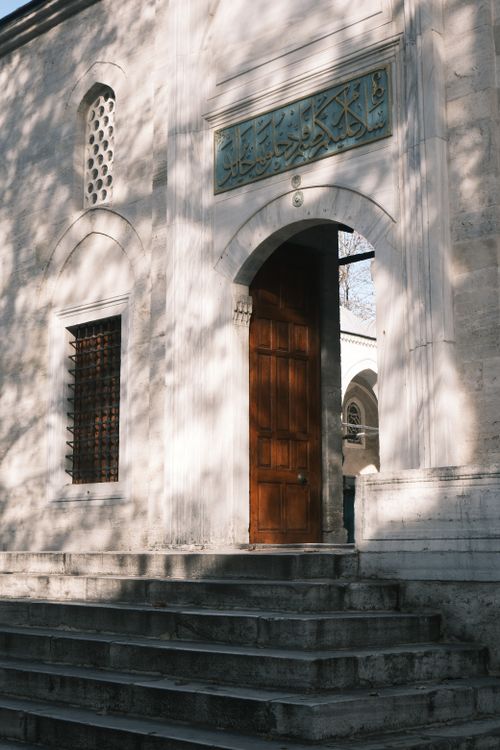 Free Old stone building with open wooden door and intricate carvings, capturing sunlight and shadows. Stock Photo