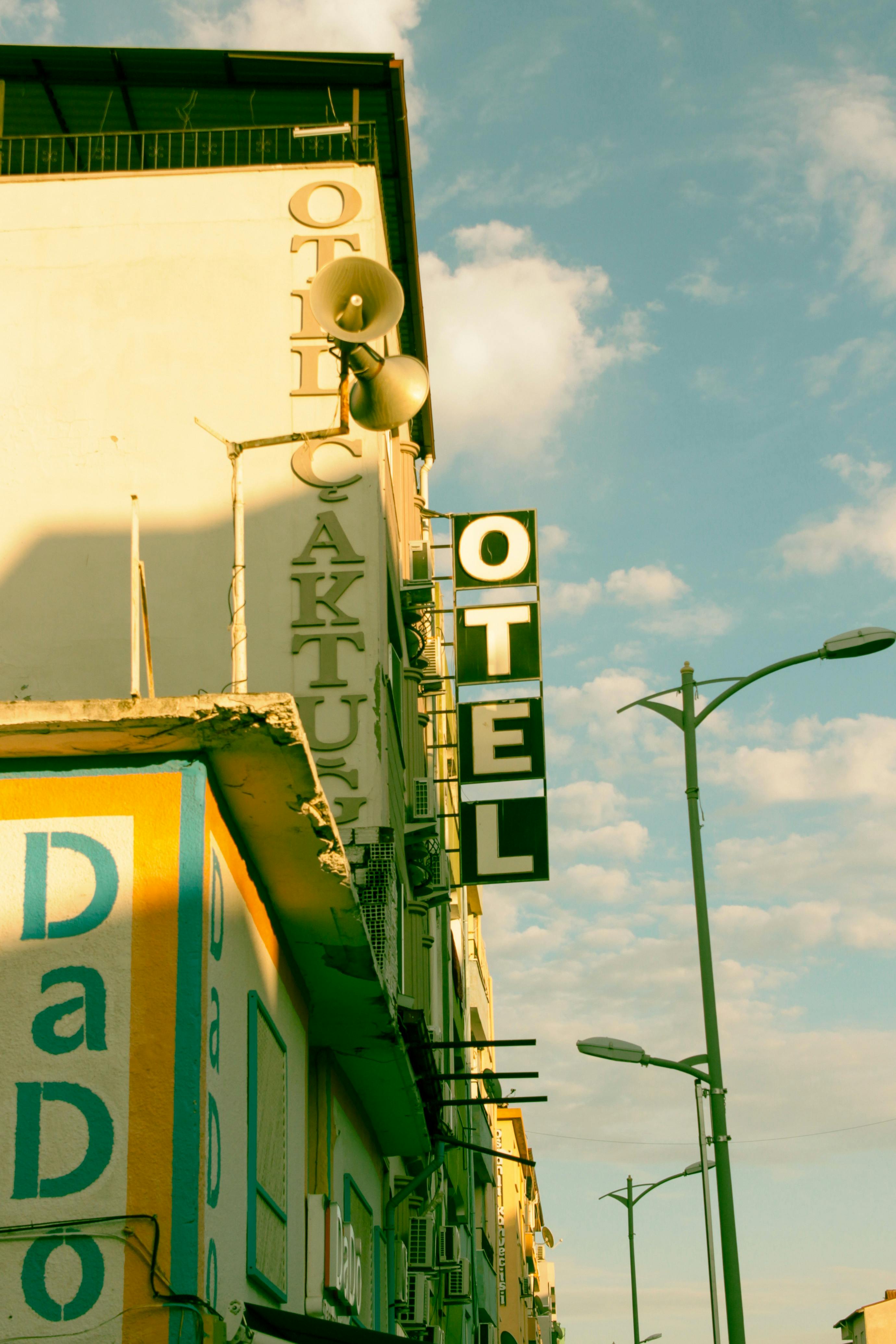 Vintage-style hotel sign against a clear sky, capturing classic architectural design.