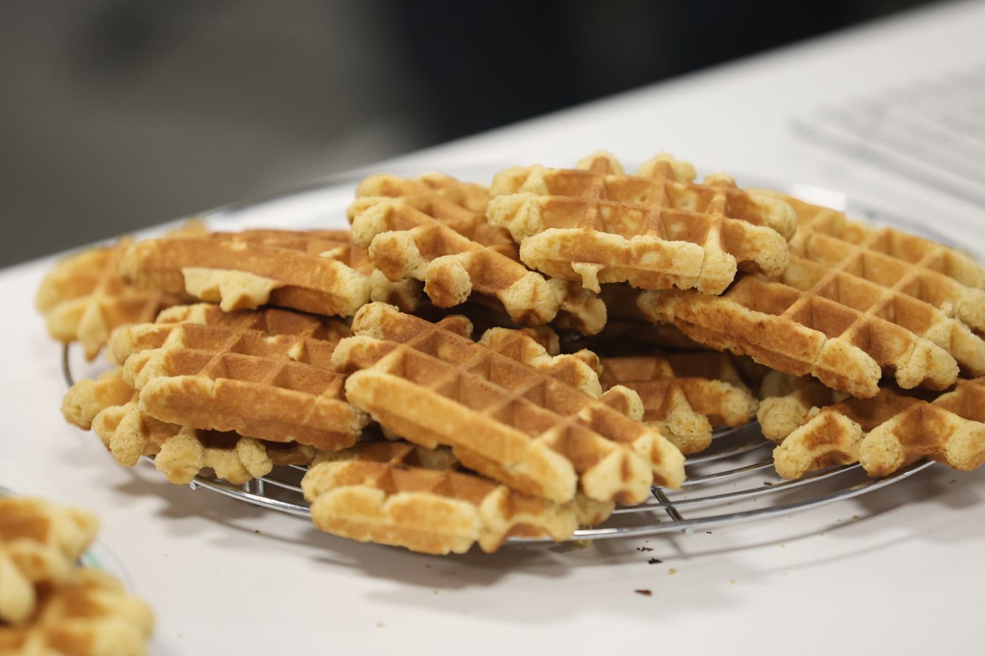 Golden homemade waffles cooling on a wire rack
