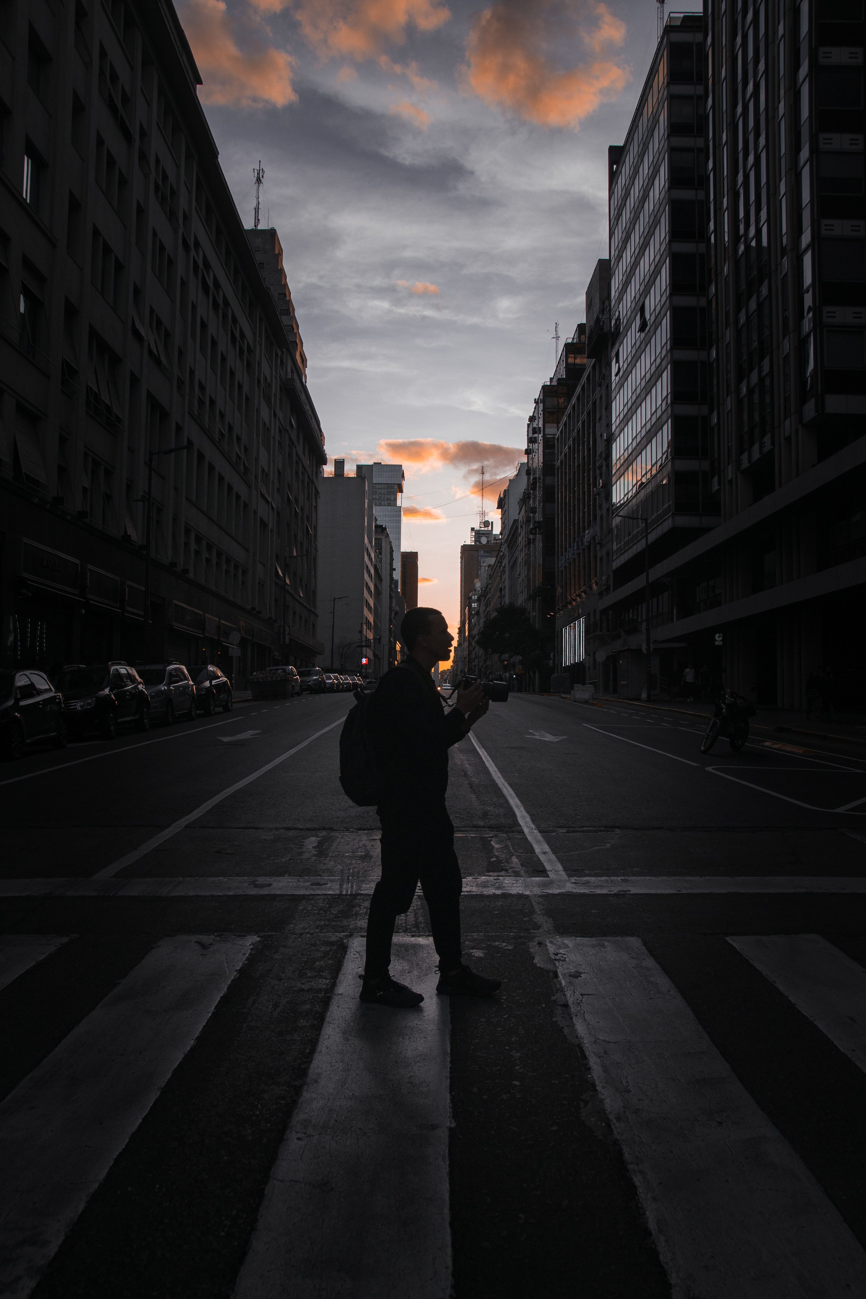 Silhouette of Man Walking in Urban Street at Dusk · Free Stock Photo
