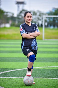 A young woman poses confidently on a soccer field in Hanoi, capturing team spirit and athleticism.