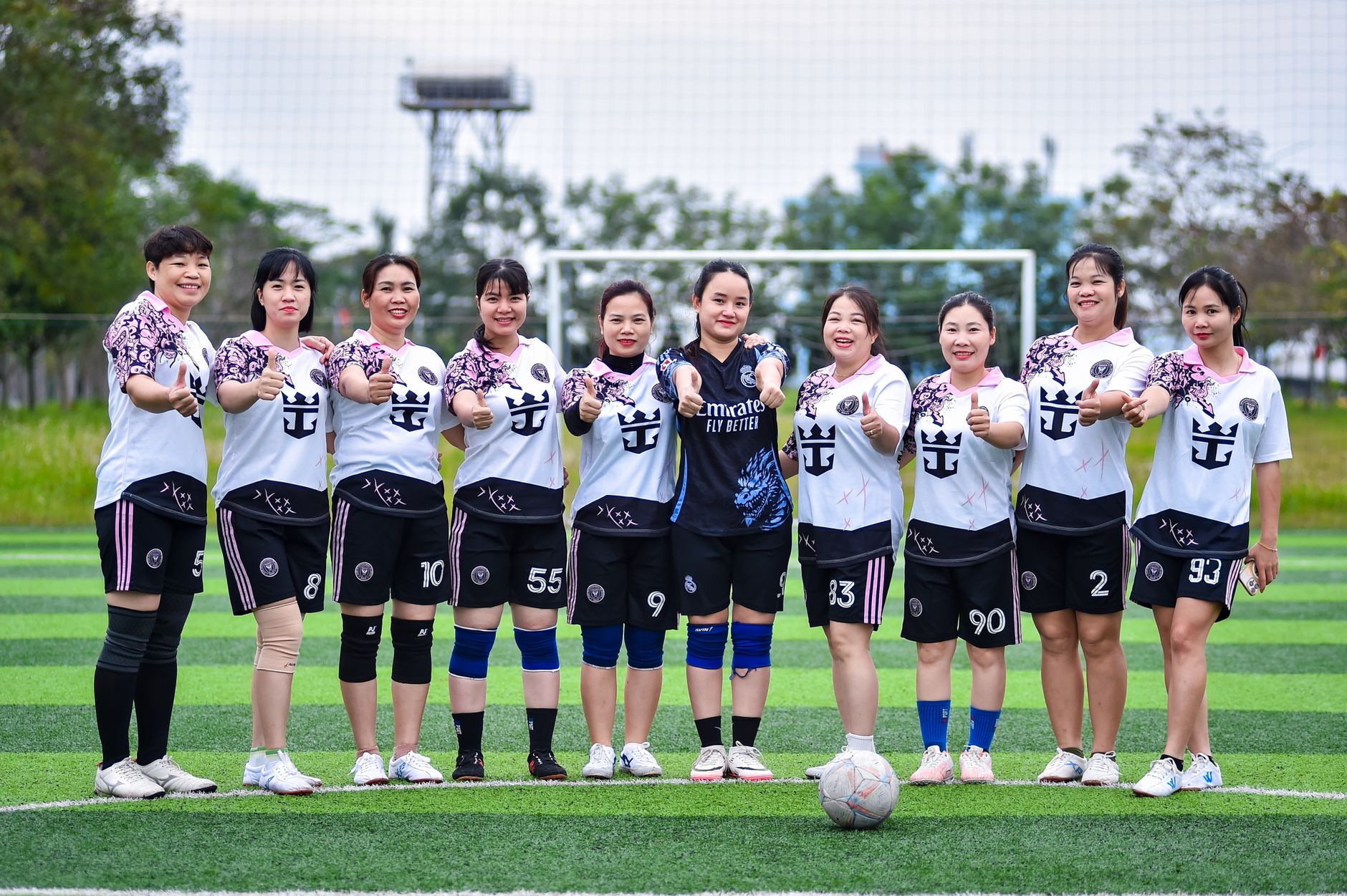 Group photo of a women's football team posing on a field in Hanoi, Vietnam.