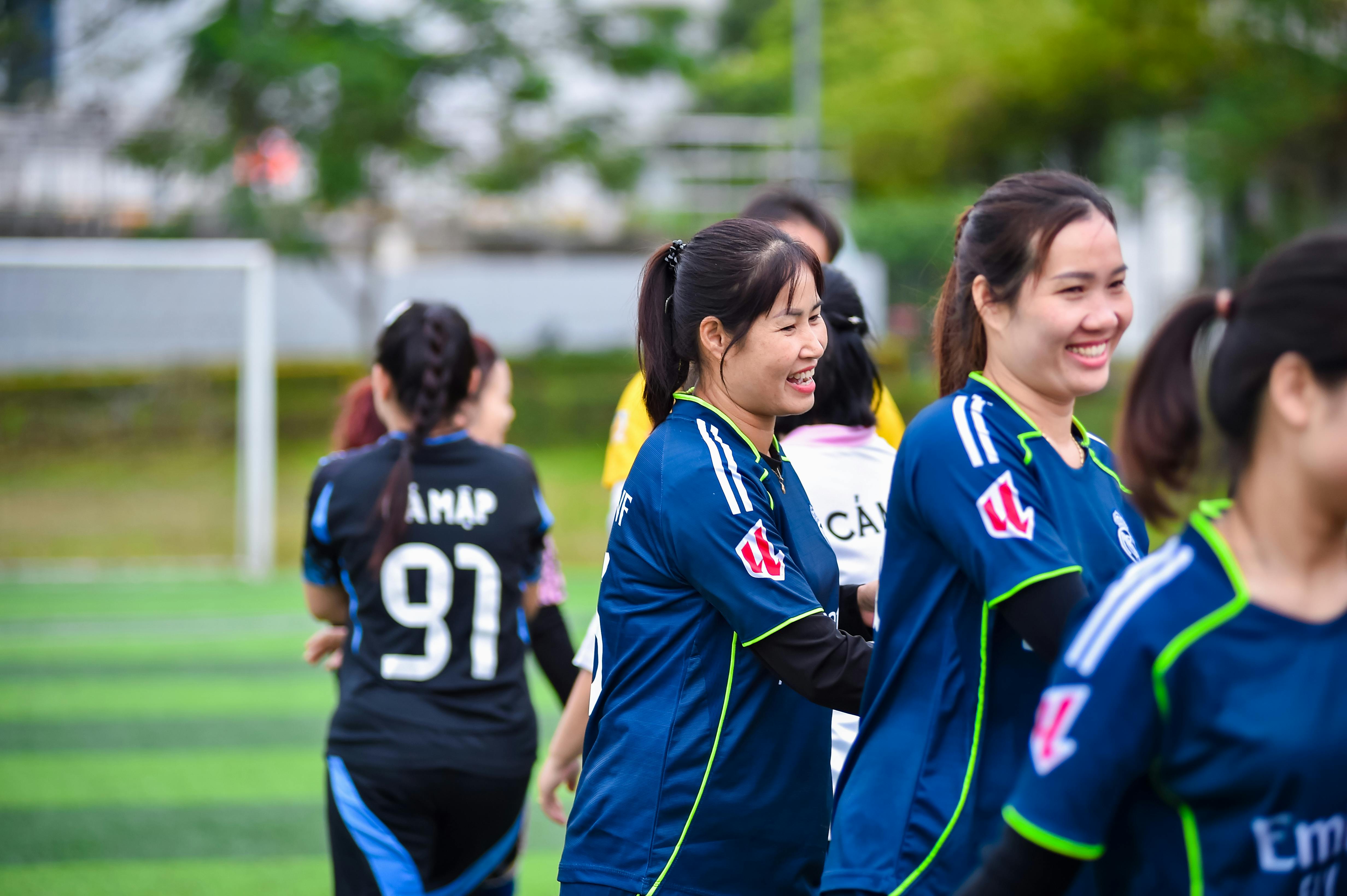 Vibrant scene of a women's football team celebrating on the field in Hà Nội, Việt Nam.