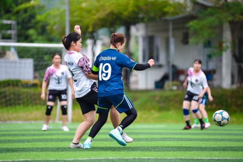 Free Exciting women's football action capturing team spirit on a vibrant field in Hà Nội, Vietnam. Stock Photo