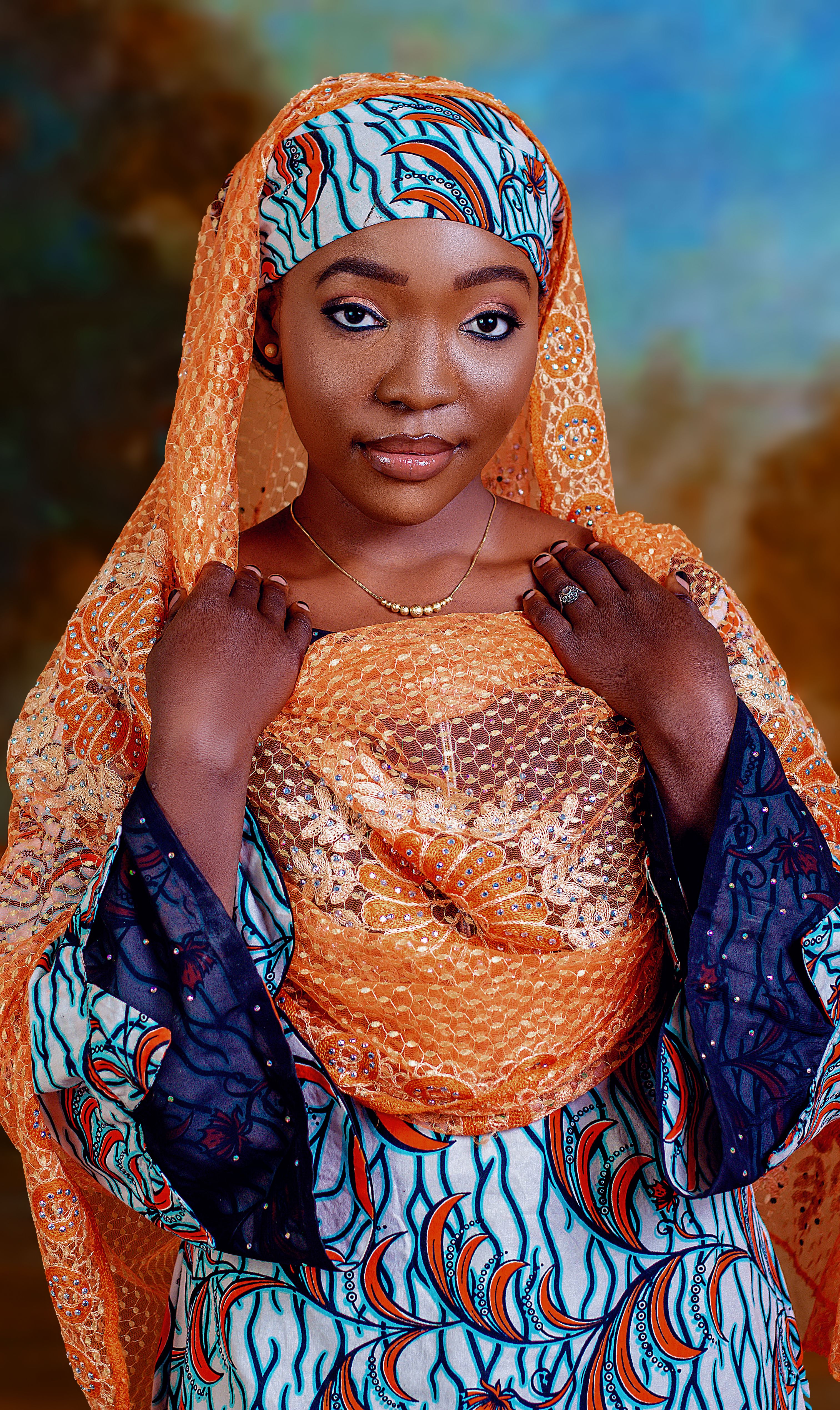 Portrait of an elegant woman wearing vibrant traditional African clothing and headscarf.