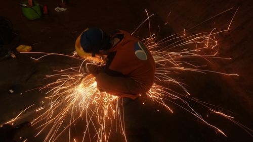 Free Welder in action with sparks flying in an industrial setting. Stock Photo