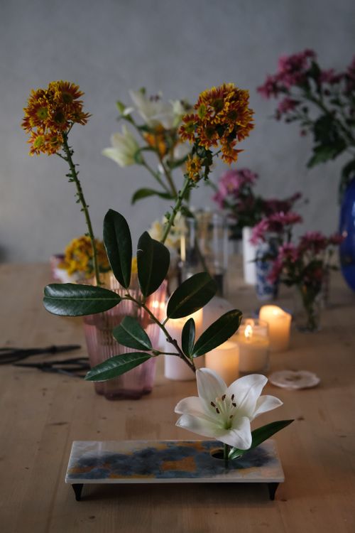 Free Beautiful ikebana display with candles on a wooden table, exuding elegance. Stock Photo
