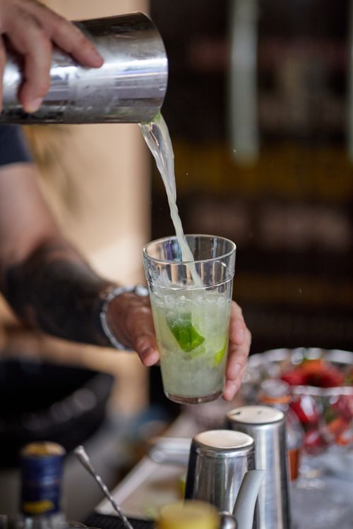 Free Bartender pours a tangy lime cocktail, perfect for a refreshing summer drink. Stock Photo
