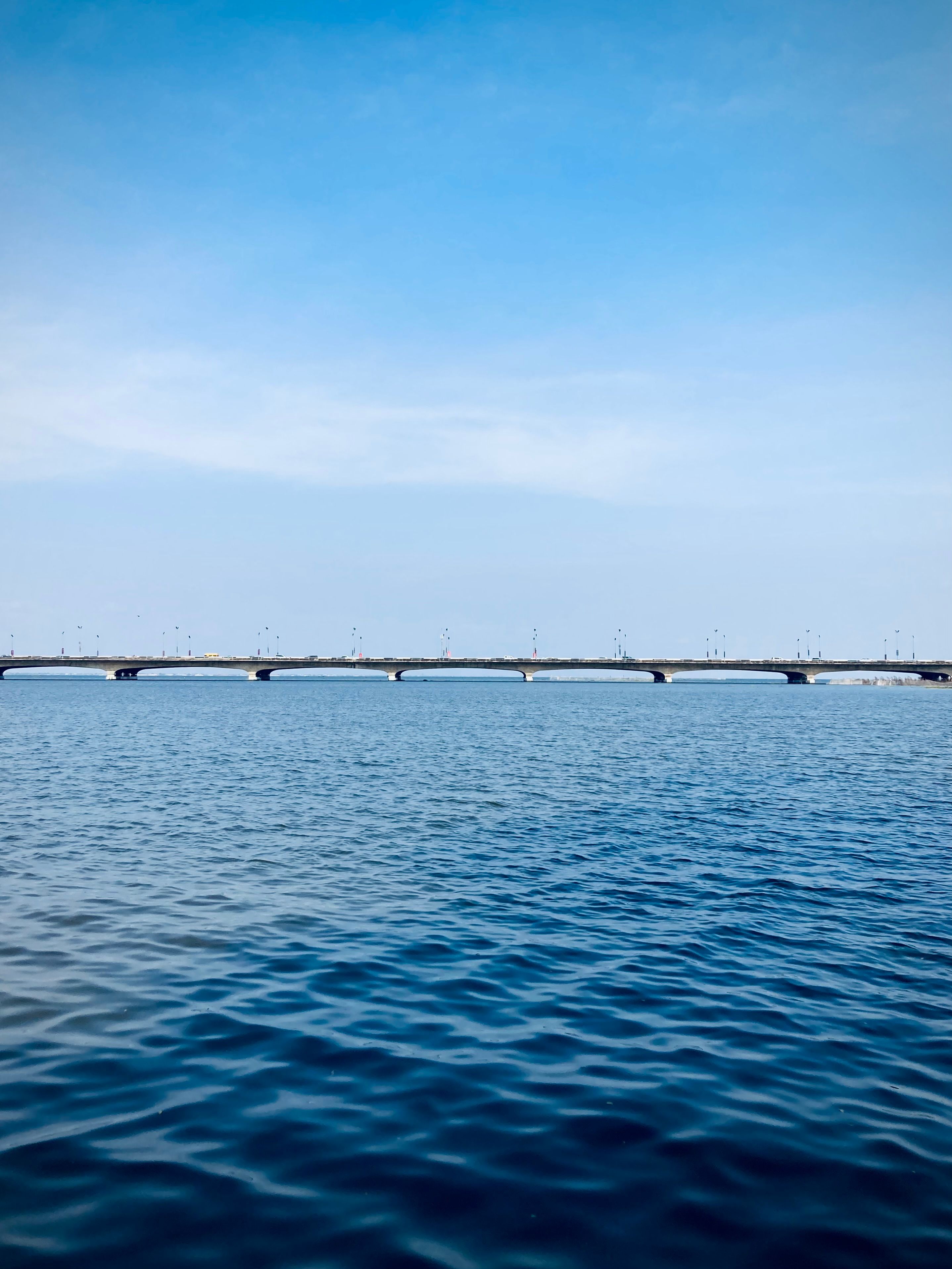 Beautiful view of Eko Bridge stretching over tranquil waters, under a clear blue sky in Lagos, Nigeria.