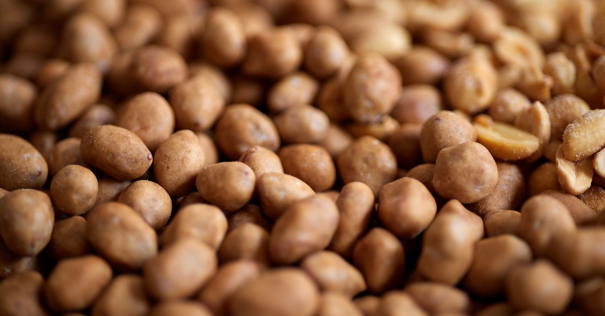 Close-up of roasted peanuts and coffee grounds on a wooden cutting board