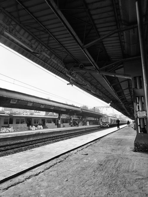 Free Black and white image of an empty train station platform, showcasing the architectural details. Stock Photo