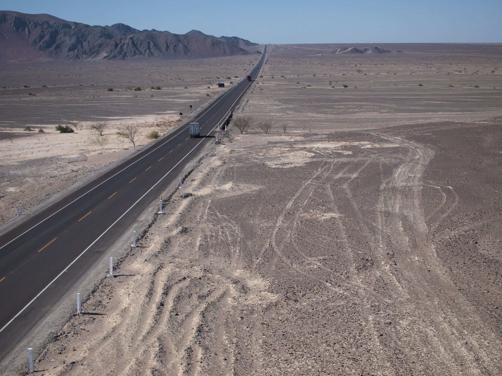 Explore the vast Nazca Desert and its geoglyphs from above, featuring the Pan-American Highway.