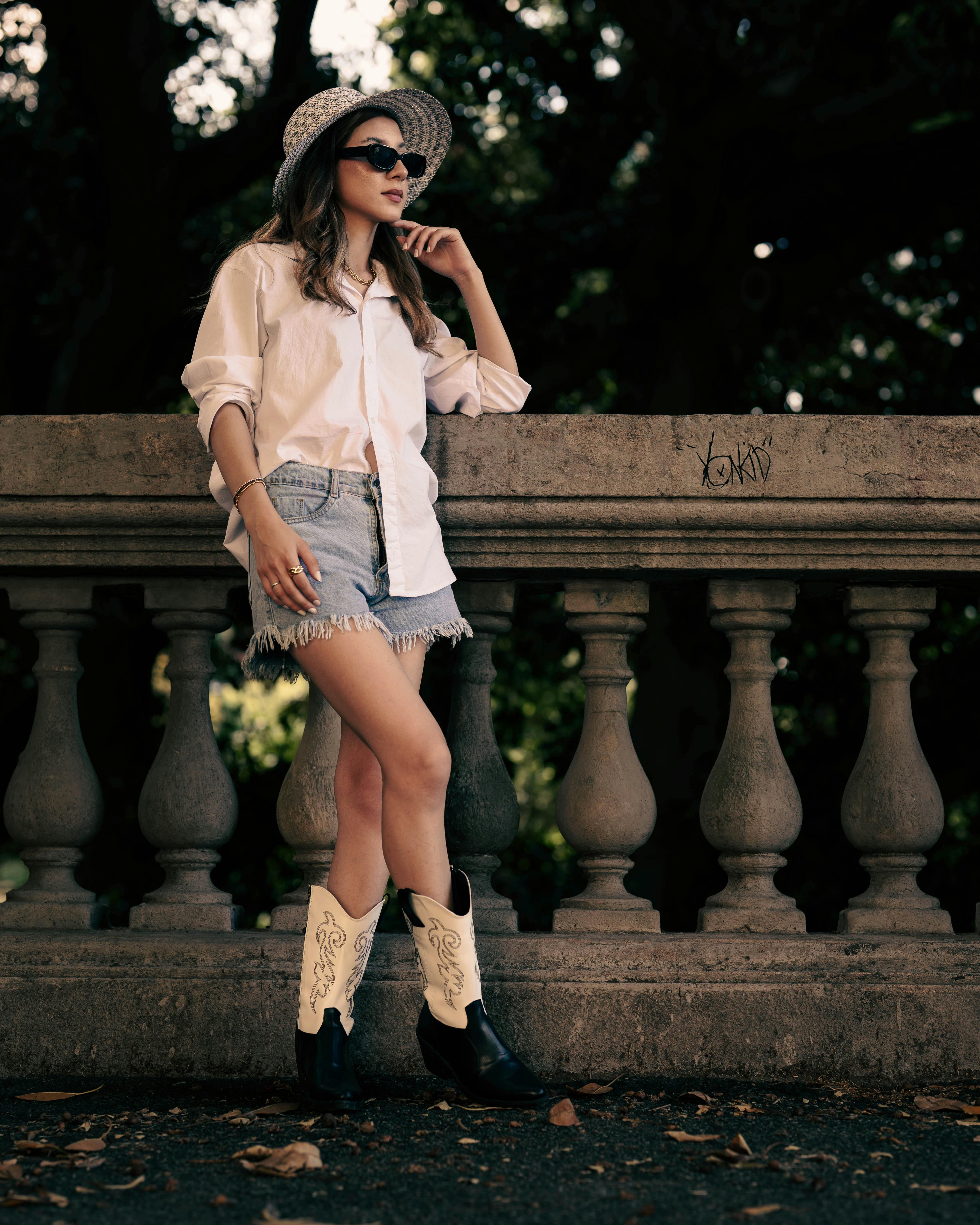 Fashionable woman in summer outfit posing outdoors with elegance and style.