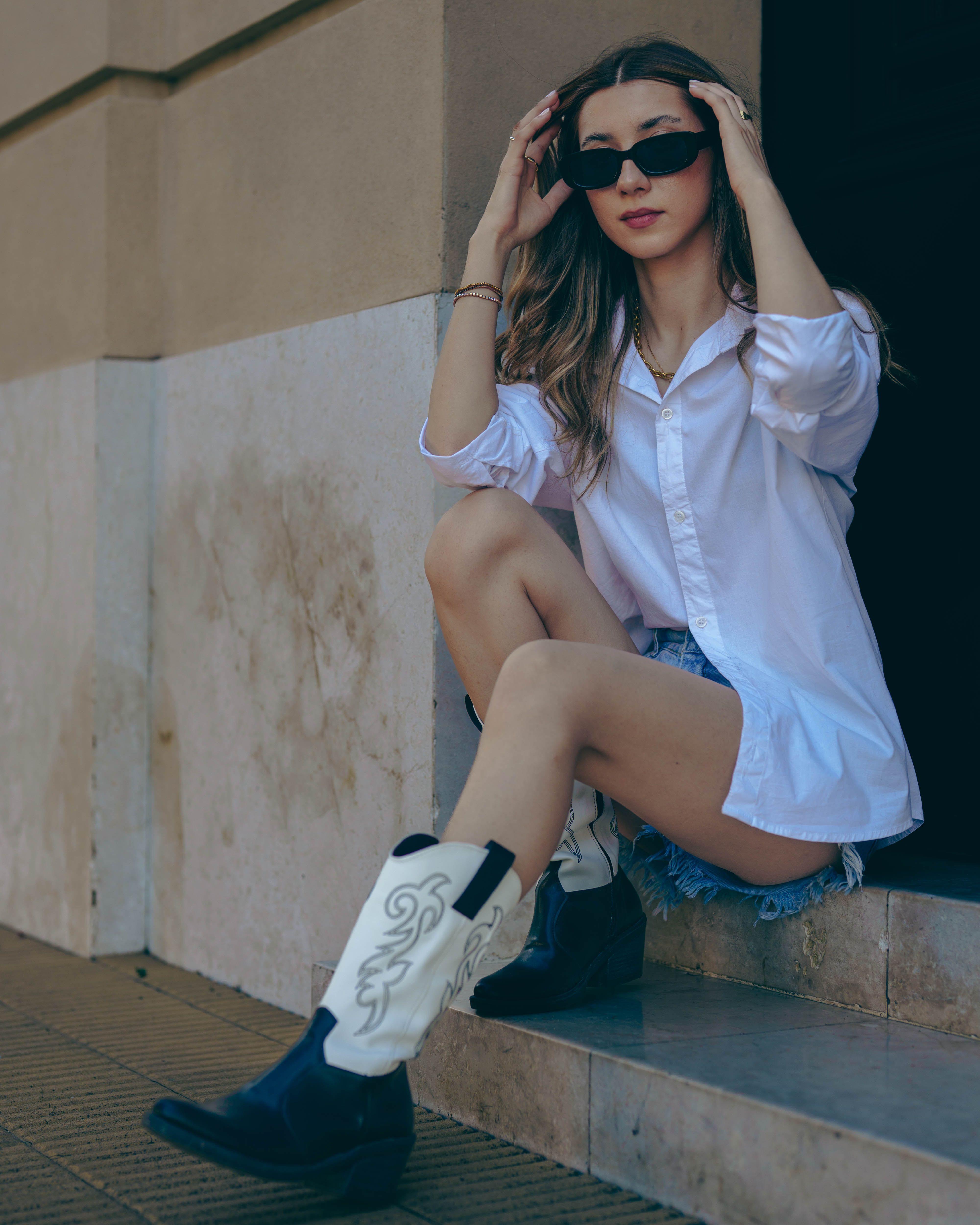 woman in chambray shirt and white jeans with tan ankle booties