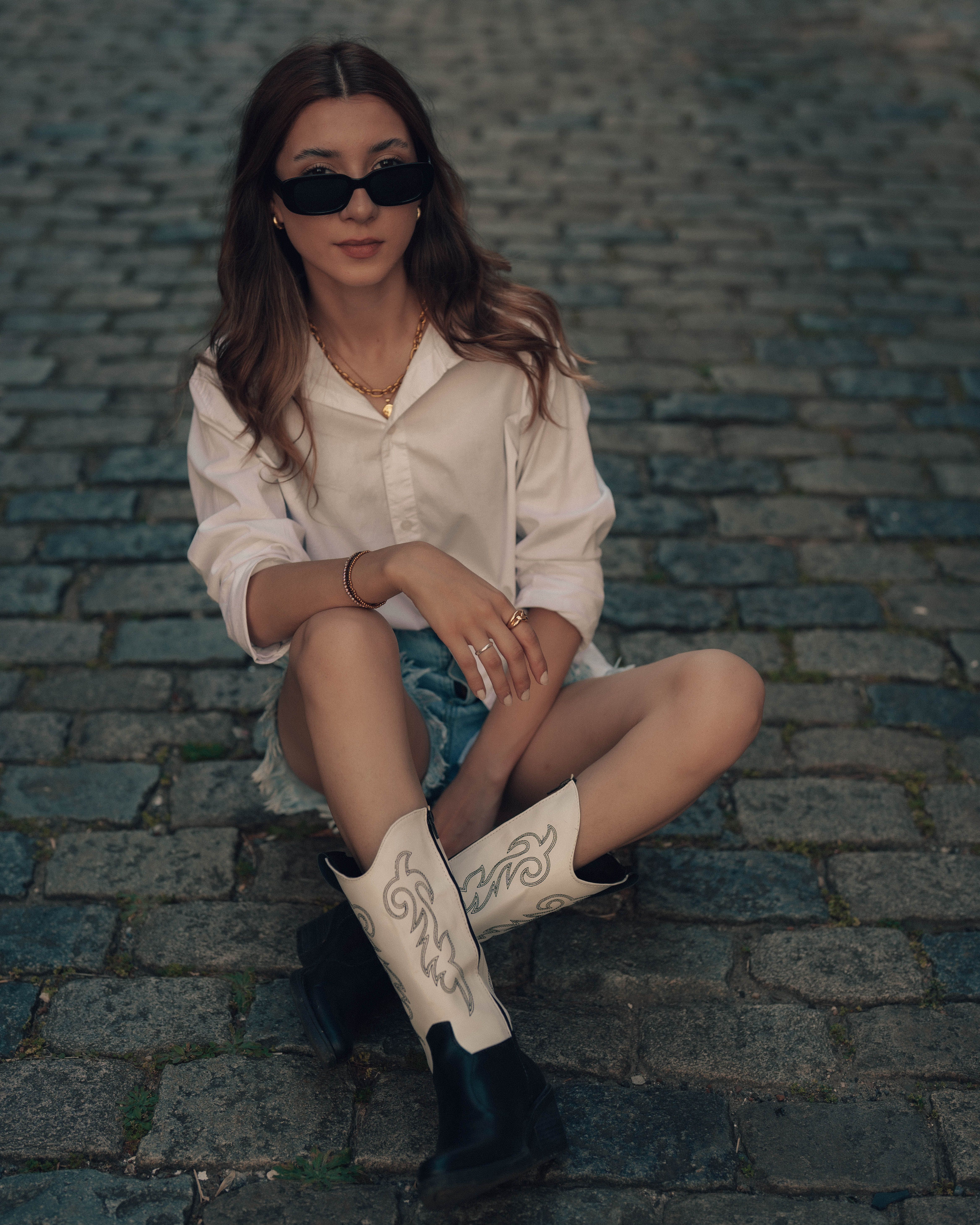 Stylish Woman in Cowboy Boots on Cobblestone Street · Free Stock Photo