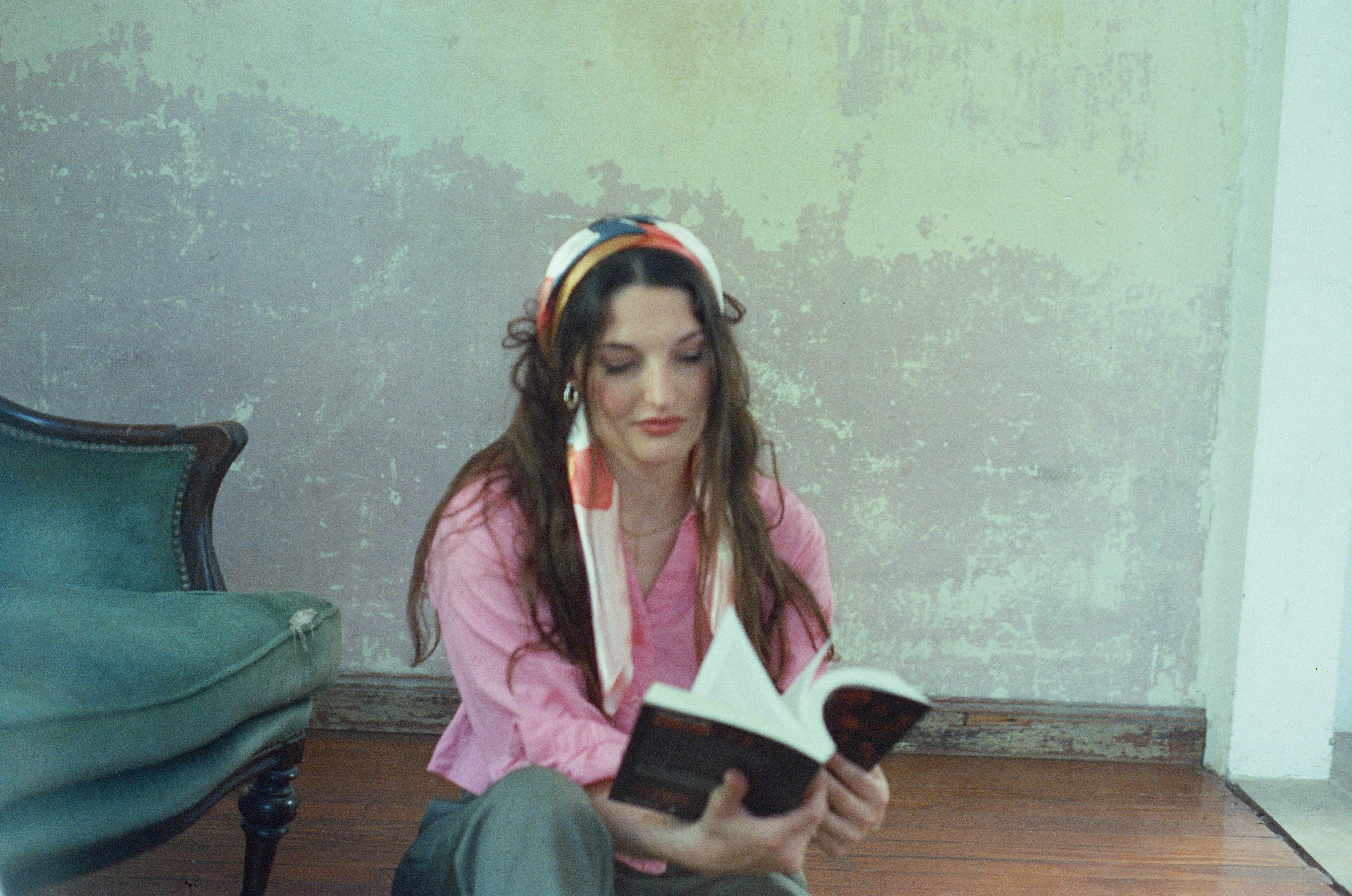 Kostnadsfria En ung kvinna med huvudduk läser en bok i ett rum i vintagestil. Stock foto